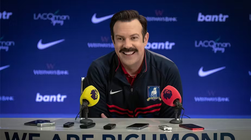 Ted Lasso, played by Jason Sudeikis, speaks at a press conference. Courtesy of Apple TV